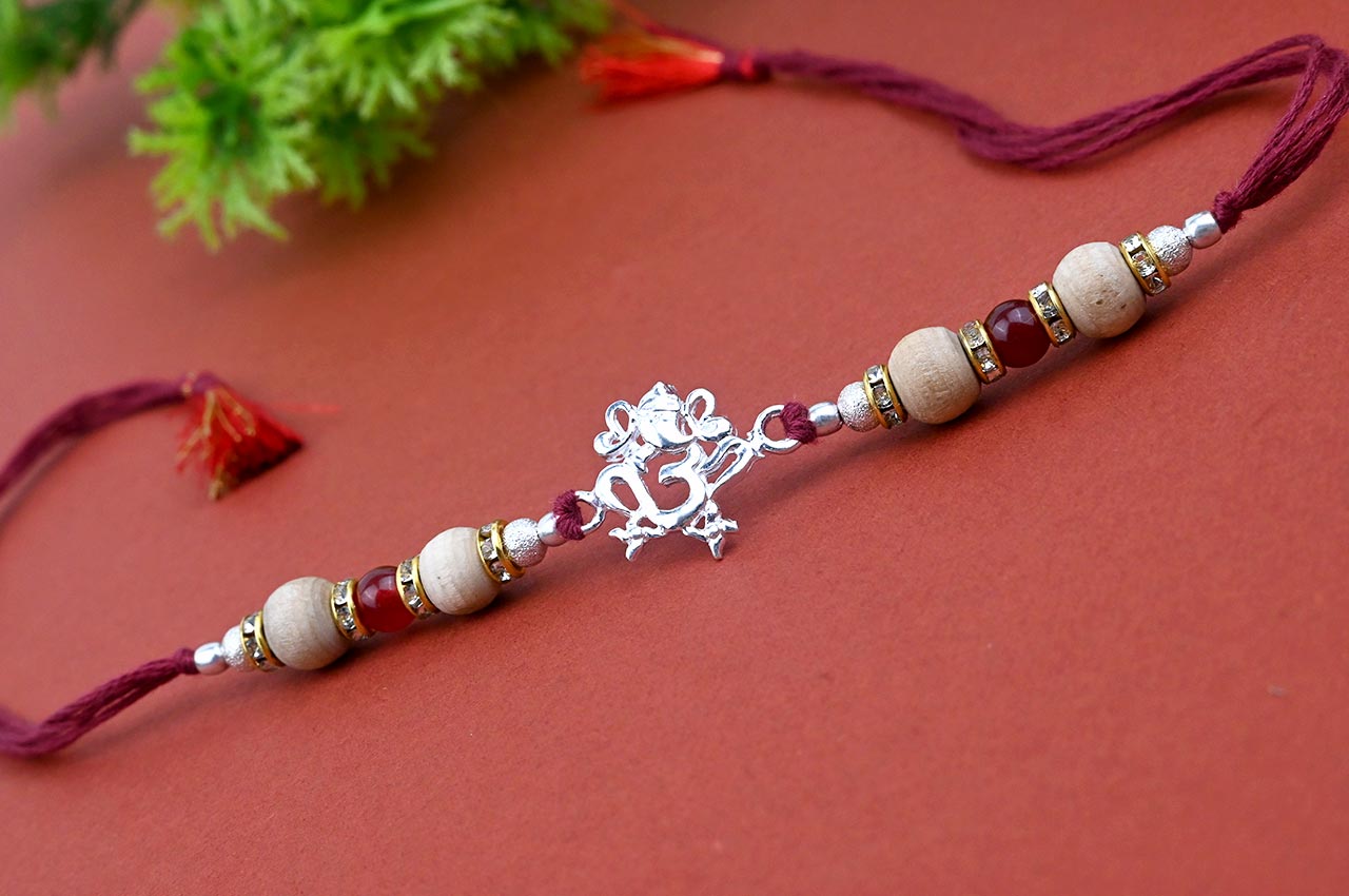 OM Design Rakhi in Pure Silver  with Sandalwood Bead in thread