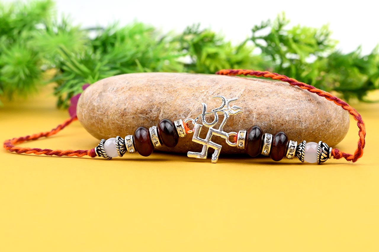 OM Design Rakhi in Pure Silver  with Red Sandalwood Bead in thread