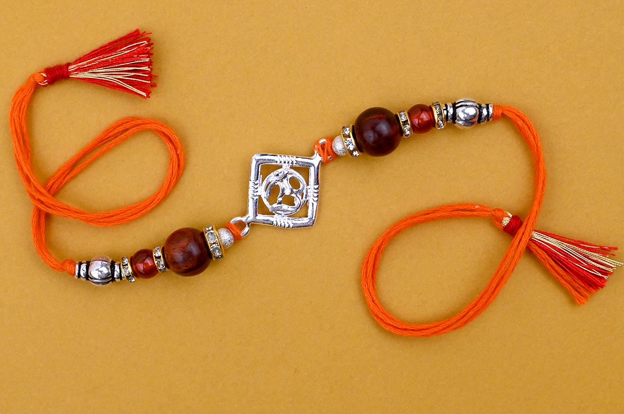 OM Design Rakhi in Pure Silver  with Red Sandalwood Bead in thread - I