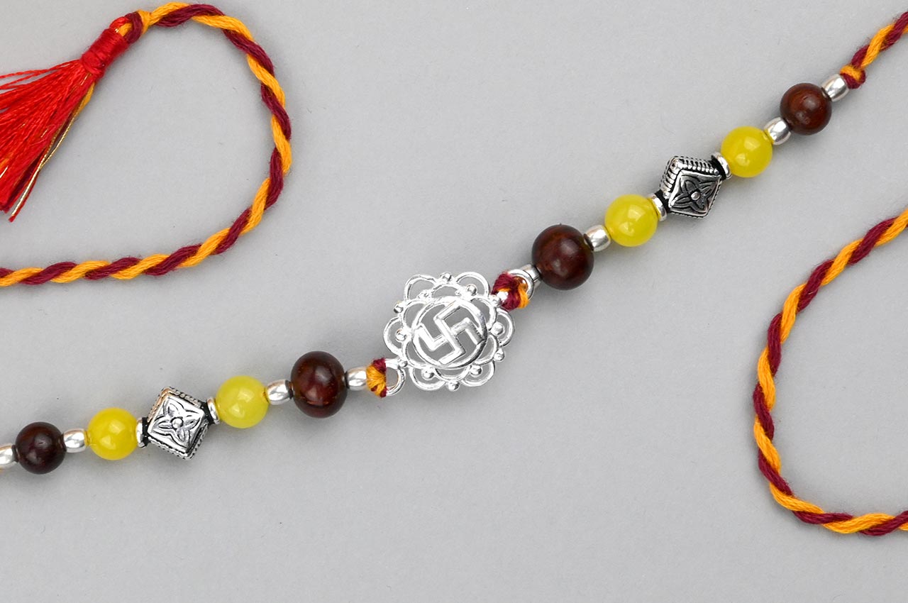 Swastik Design Rakhi in Pure Silver  with Red Sandalwood Bead in thread