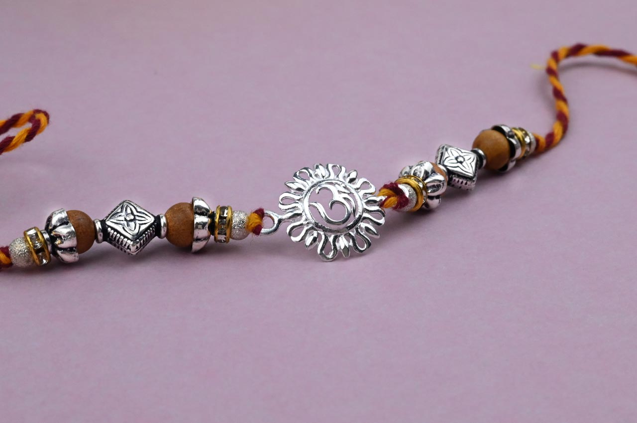 OM Design Rakhi in Pure Silver  with Sandalwood Bead in thread - II