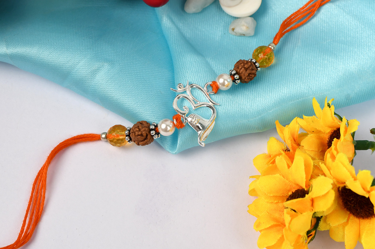 Om Rakhi With Citrine and Pearl beads